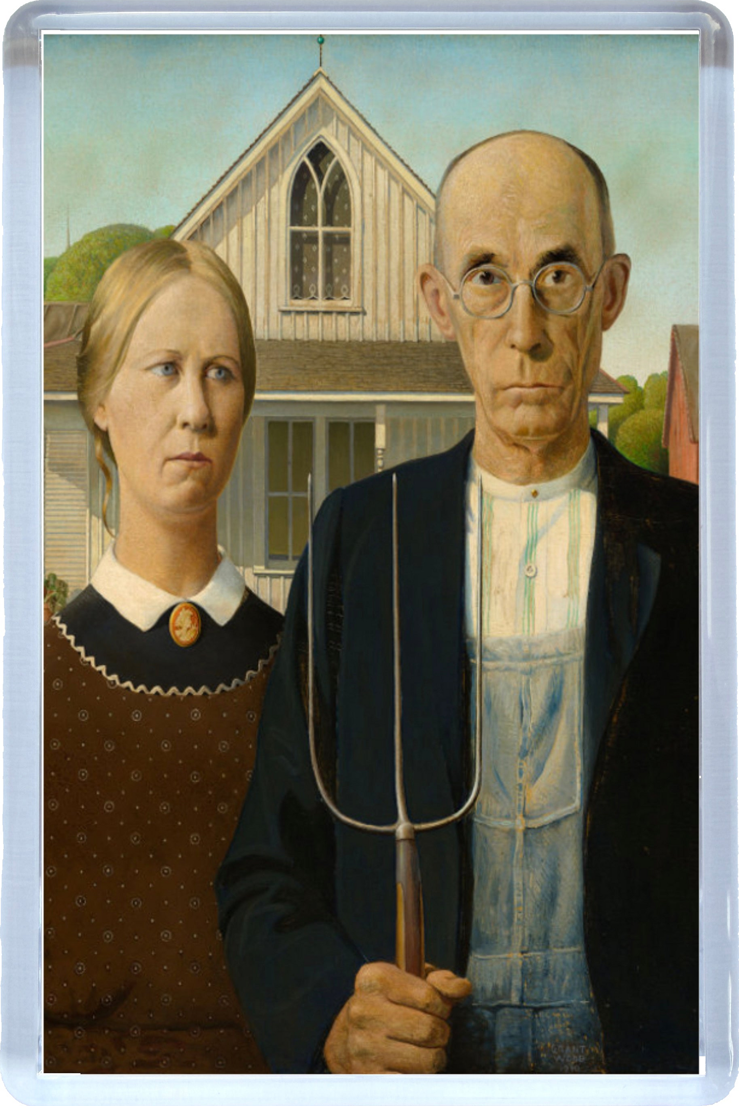 Close-up Fridge magnet with a painting of a man and woman holding a pitchfork in front of a house.