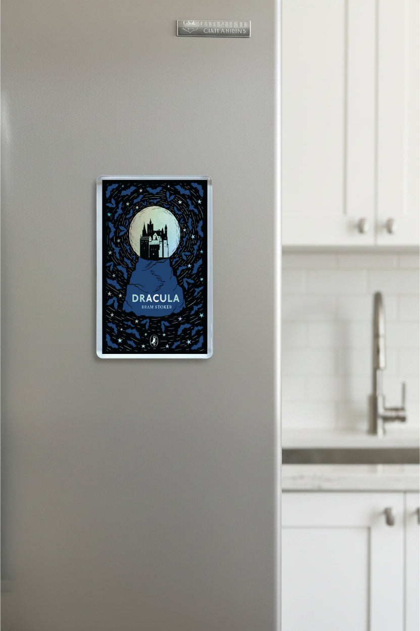 Fridge with a 'Dracula' book cover magnet on a kitchen wall.