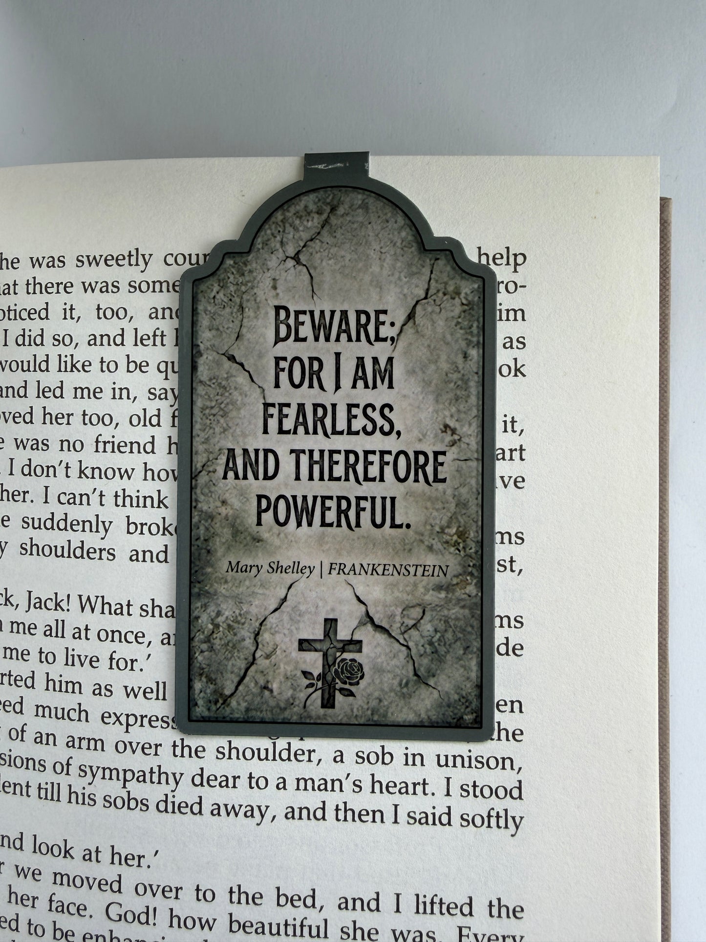 Book with a gravestone-style bookmark featuring text on a white background