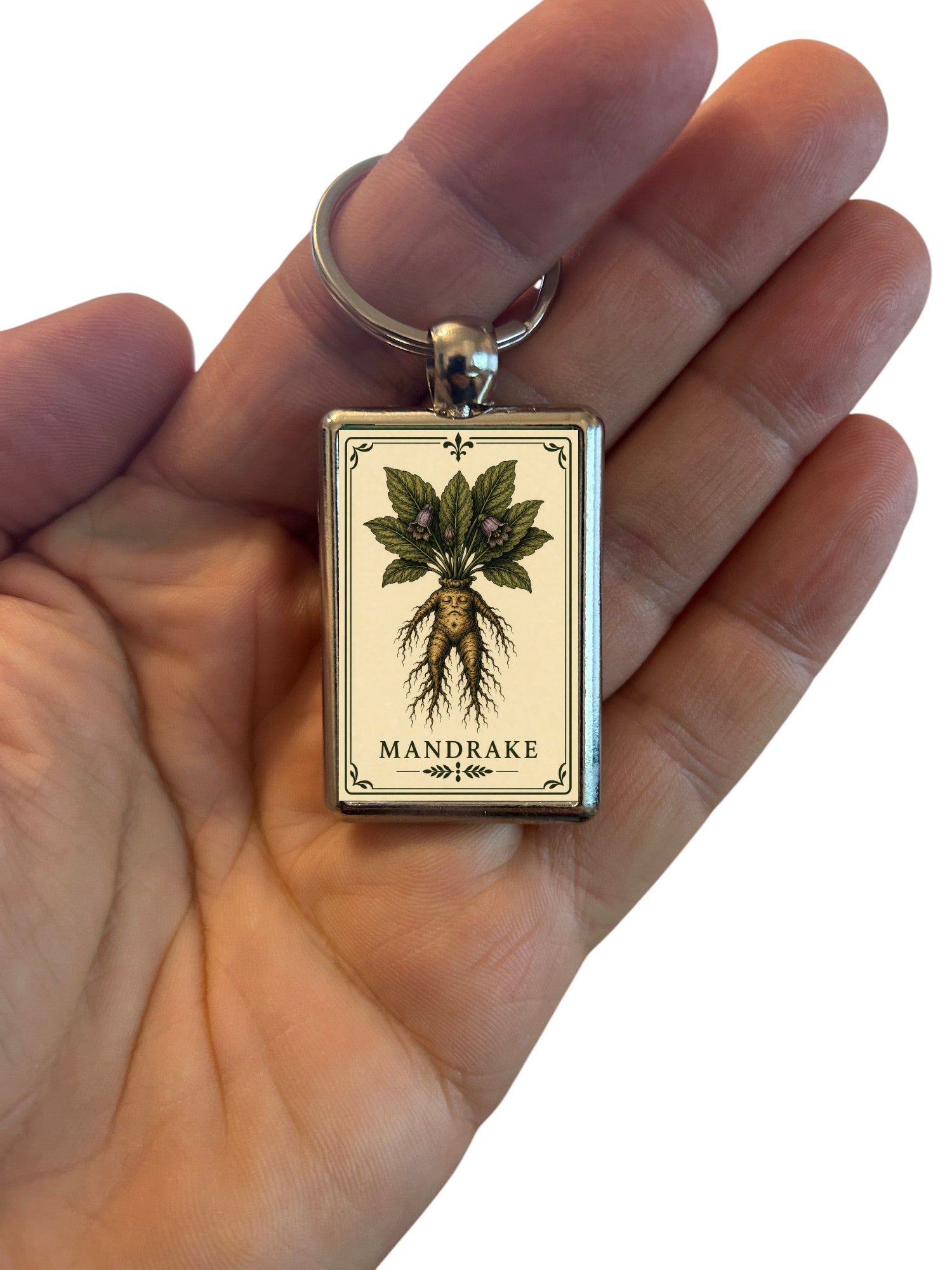 Keychain with mandrake plant charmin a hand on a white background