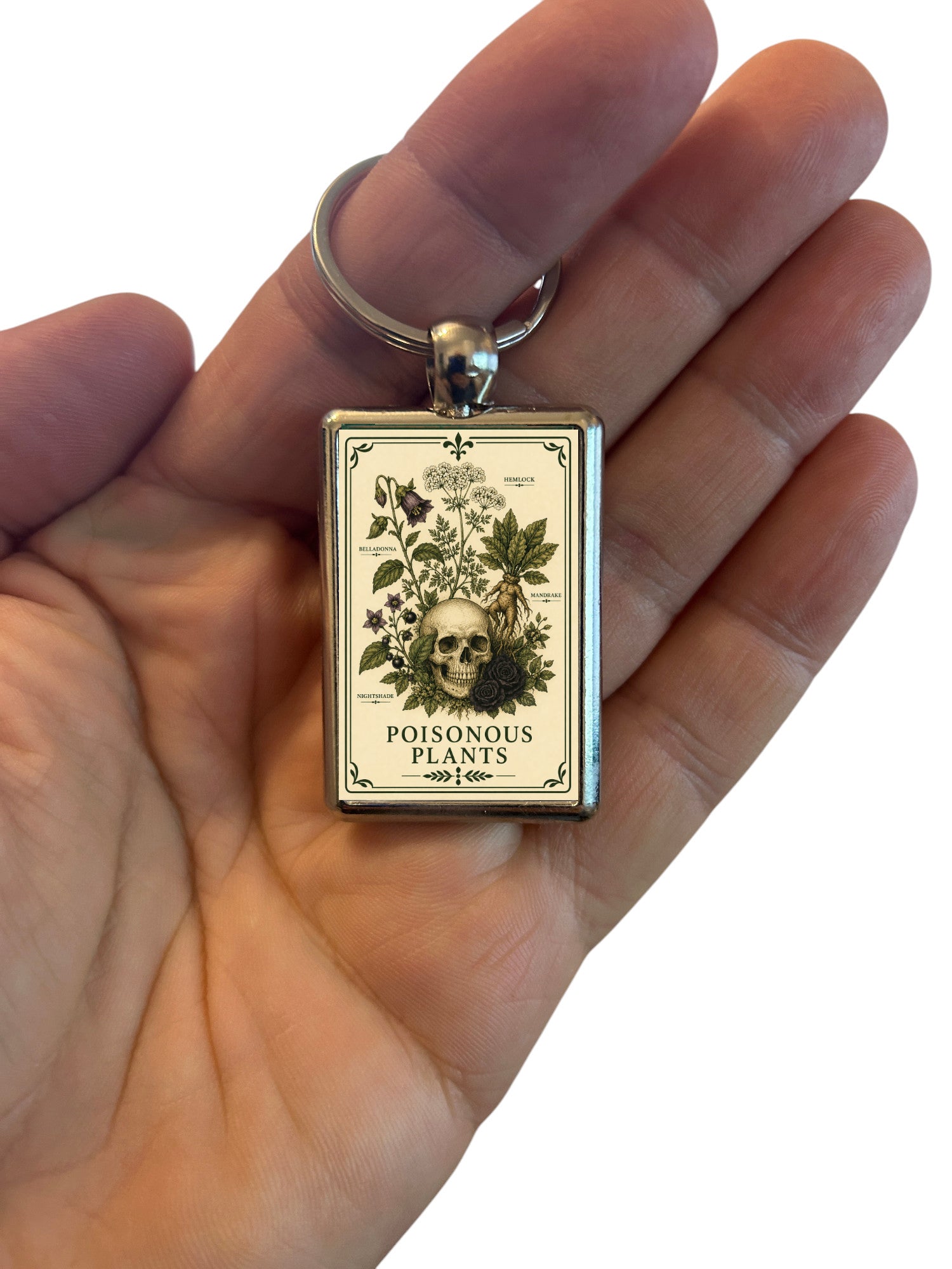 Keychain with a 'Poisonous Plants' label in a hand on a white background