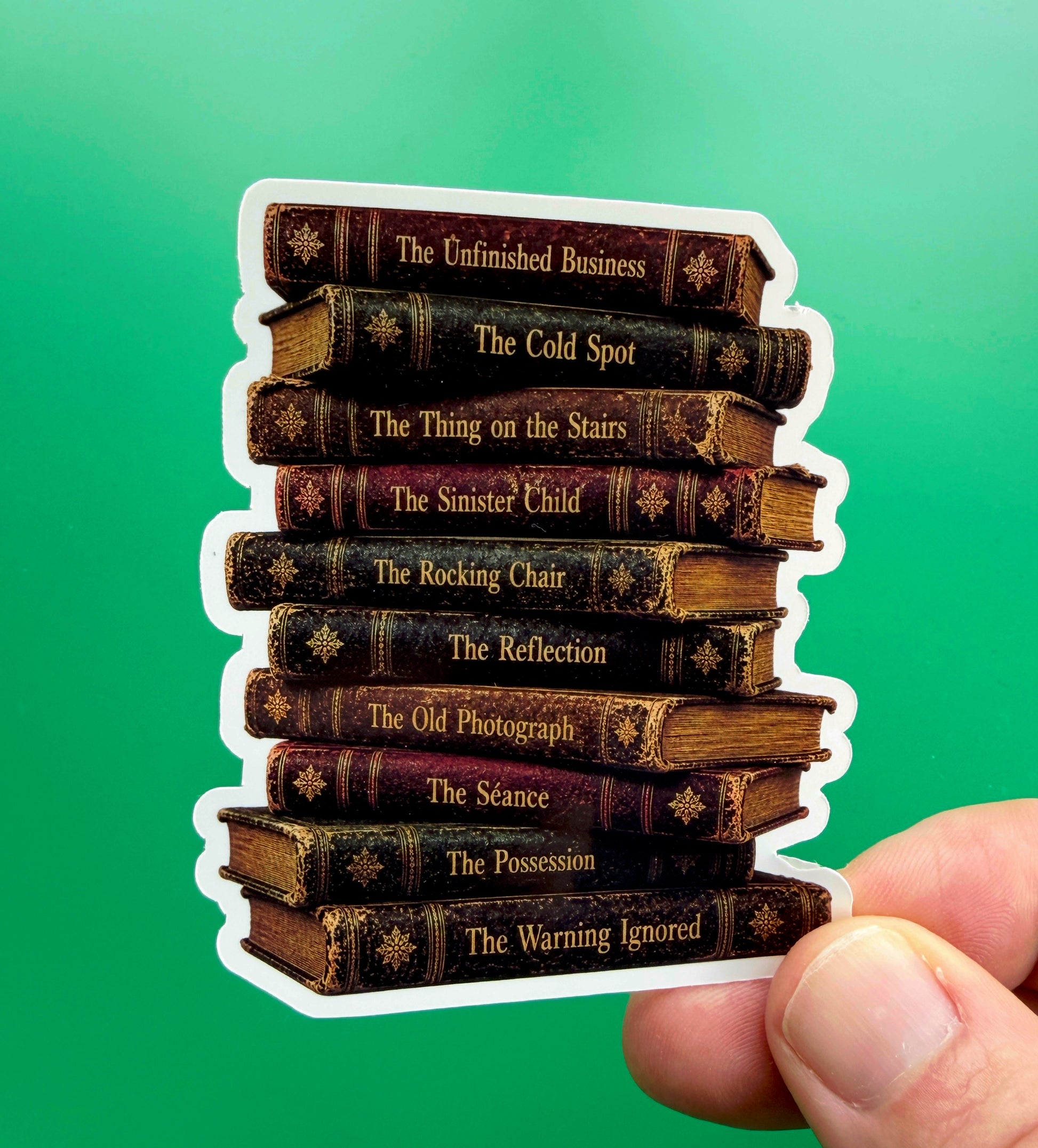 Stack of vintage book spines with titles held against a green background