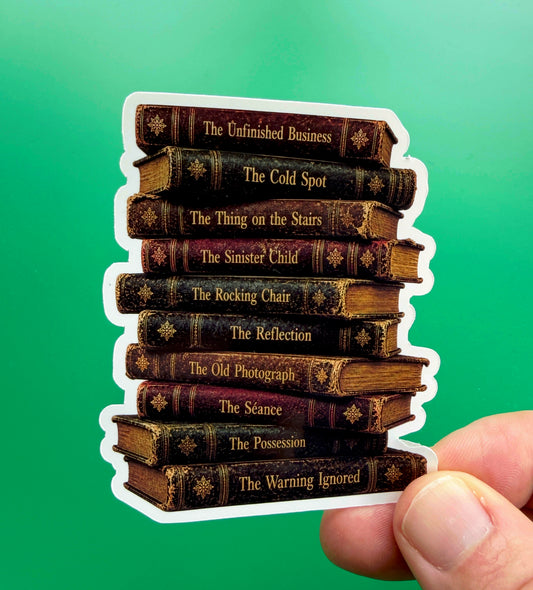 Stack of vintage book spines with titles held against a green background